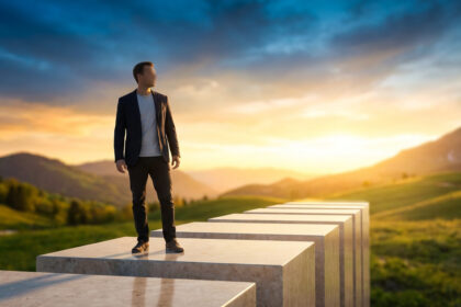 Homme sur des marches, face à un soleil levant sur un paysage vallonné, symbolisant un chemin de vie ou de progrès.